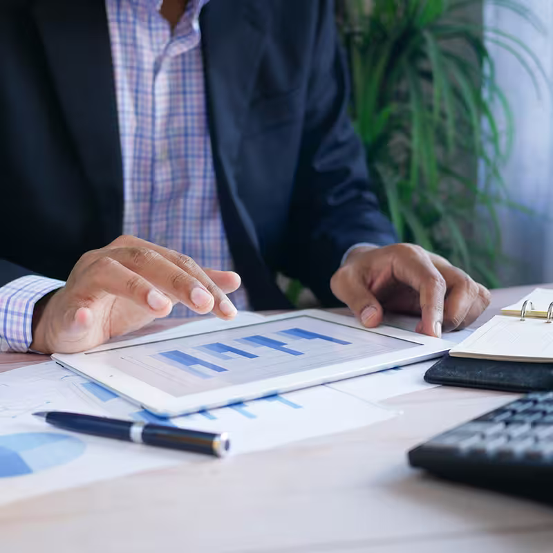 persona de traje sosteniendo usando una tableta
