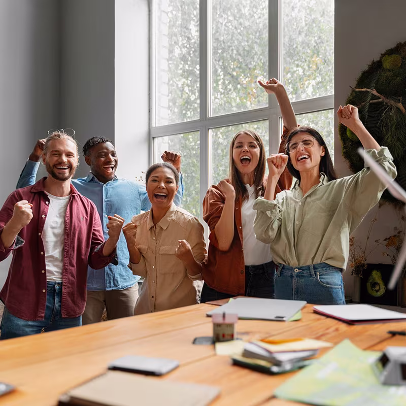 Un grupo de cinco personas celebrando en una oficina